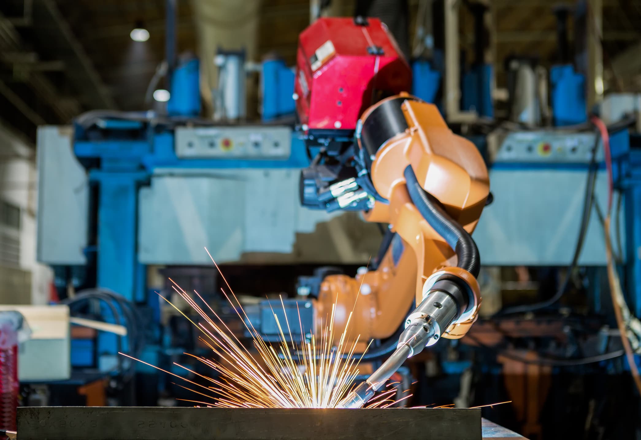 Industriell sveiserobot i drift i en produksjonshall